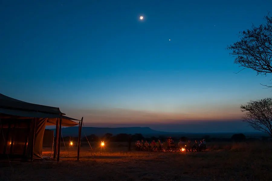 Tented camp lit up at night under the stars