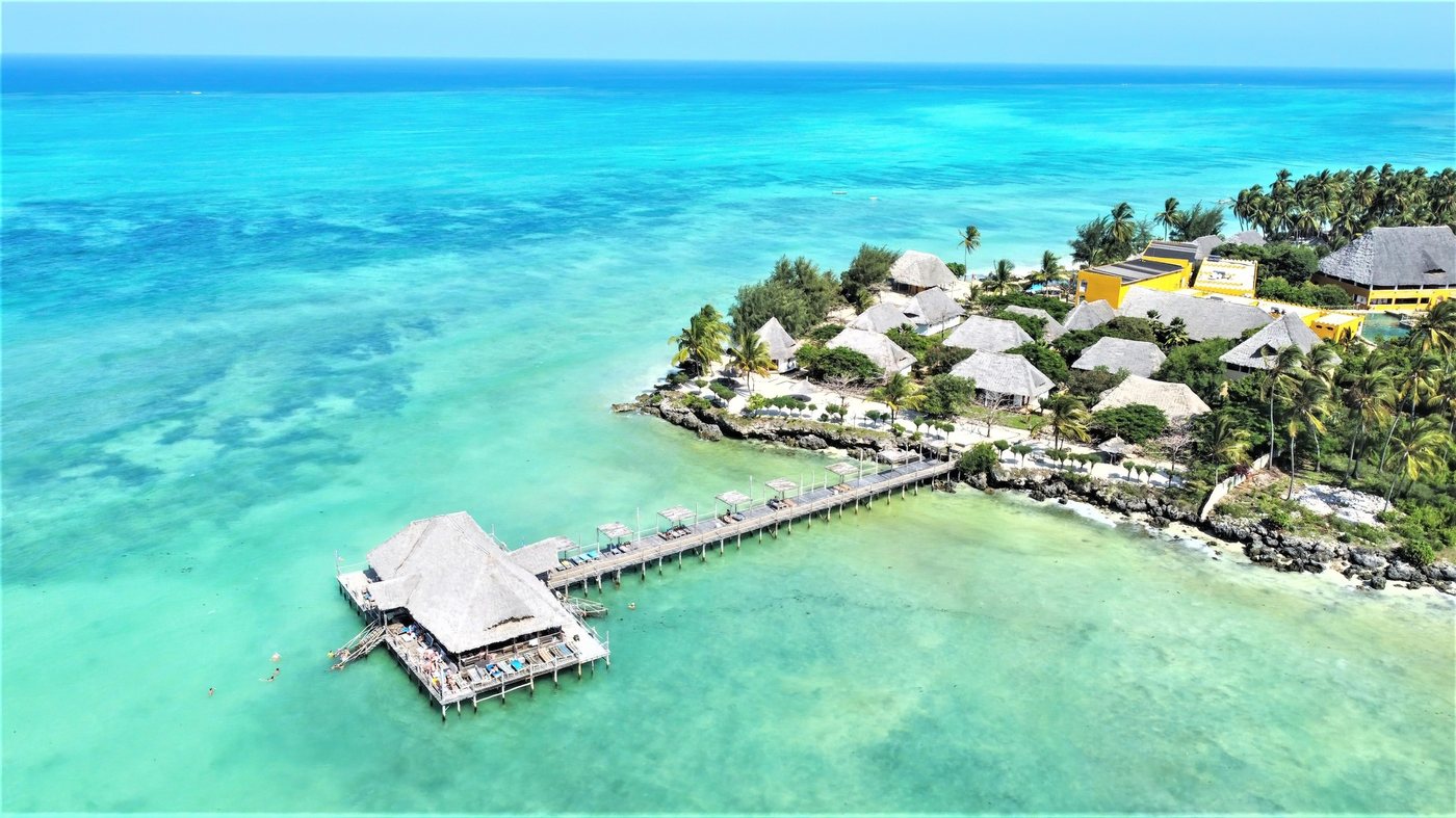Thatched beach resort on a turquoise Zanzibar shoreline